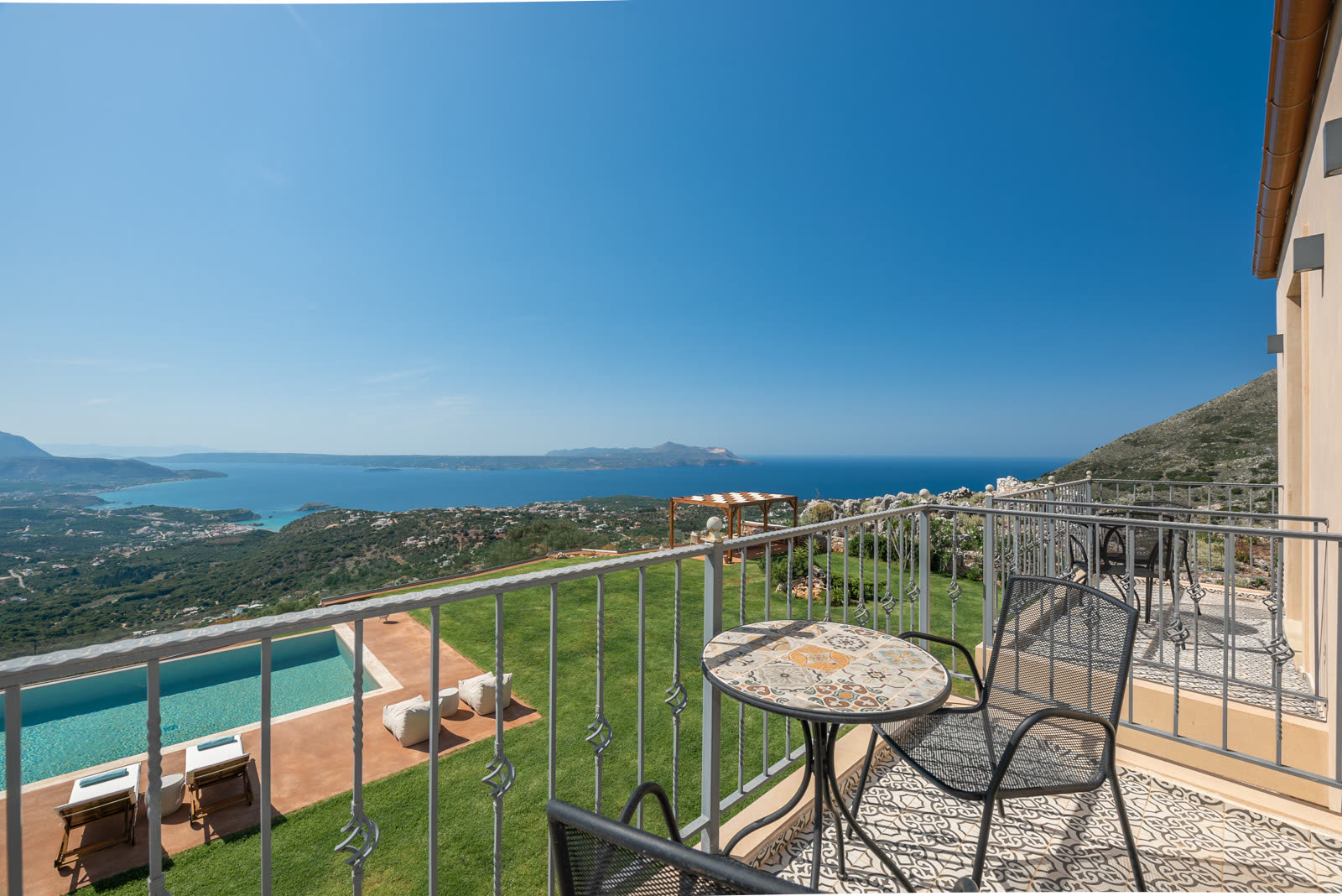 View from a balcony over the lawn, pool and Cretan coast