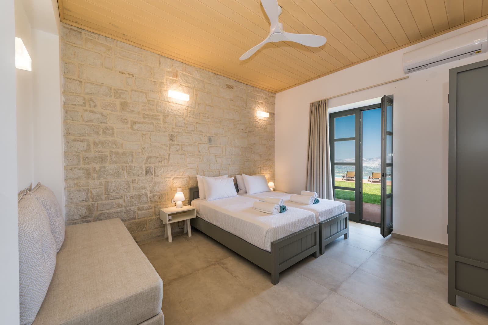 Ground-floor twin bedroom with stone feature wall and garden doors