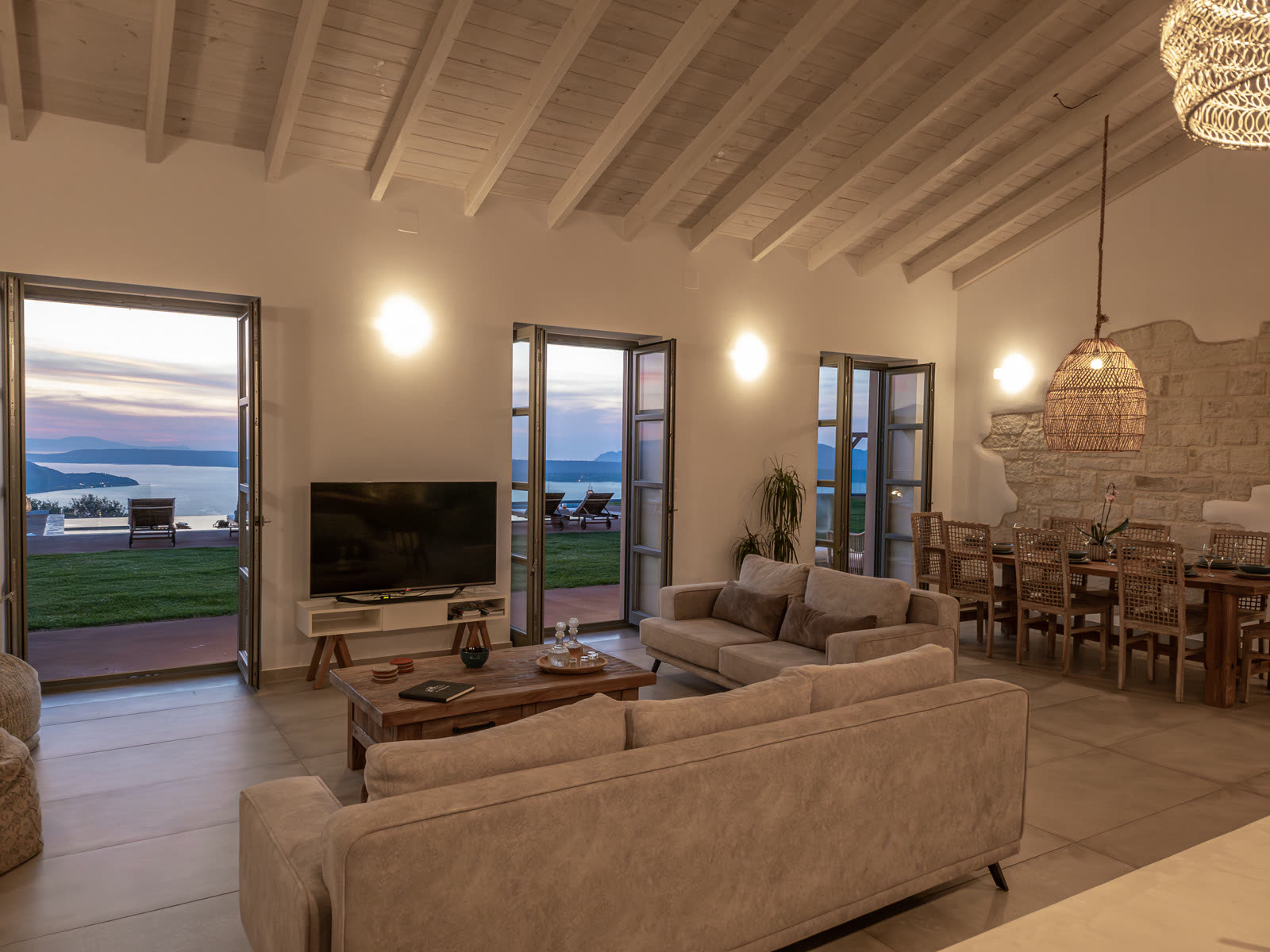 Open-concept living room with vaulted wood ceiling at dusk