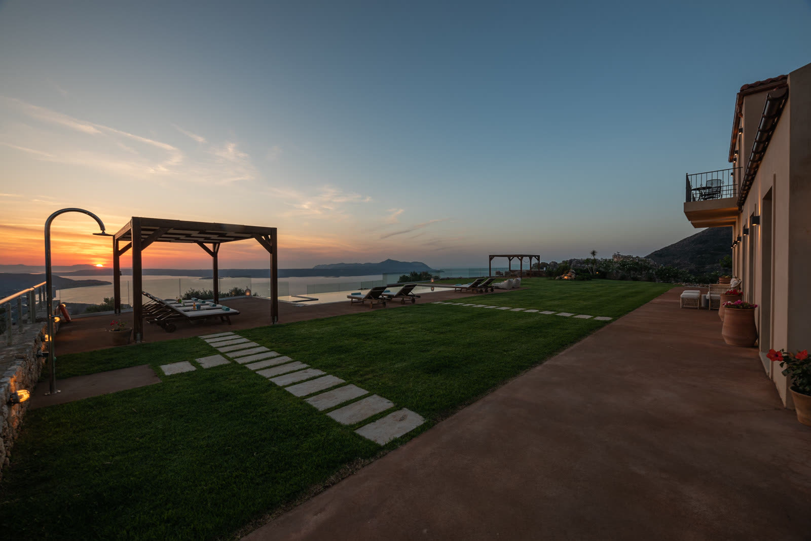 Sunset over the lawn, infinity pool and north coast from Aquila Villa