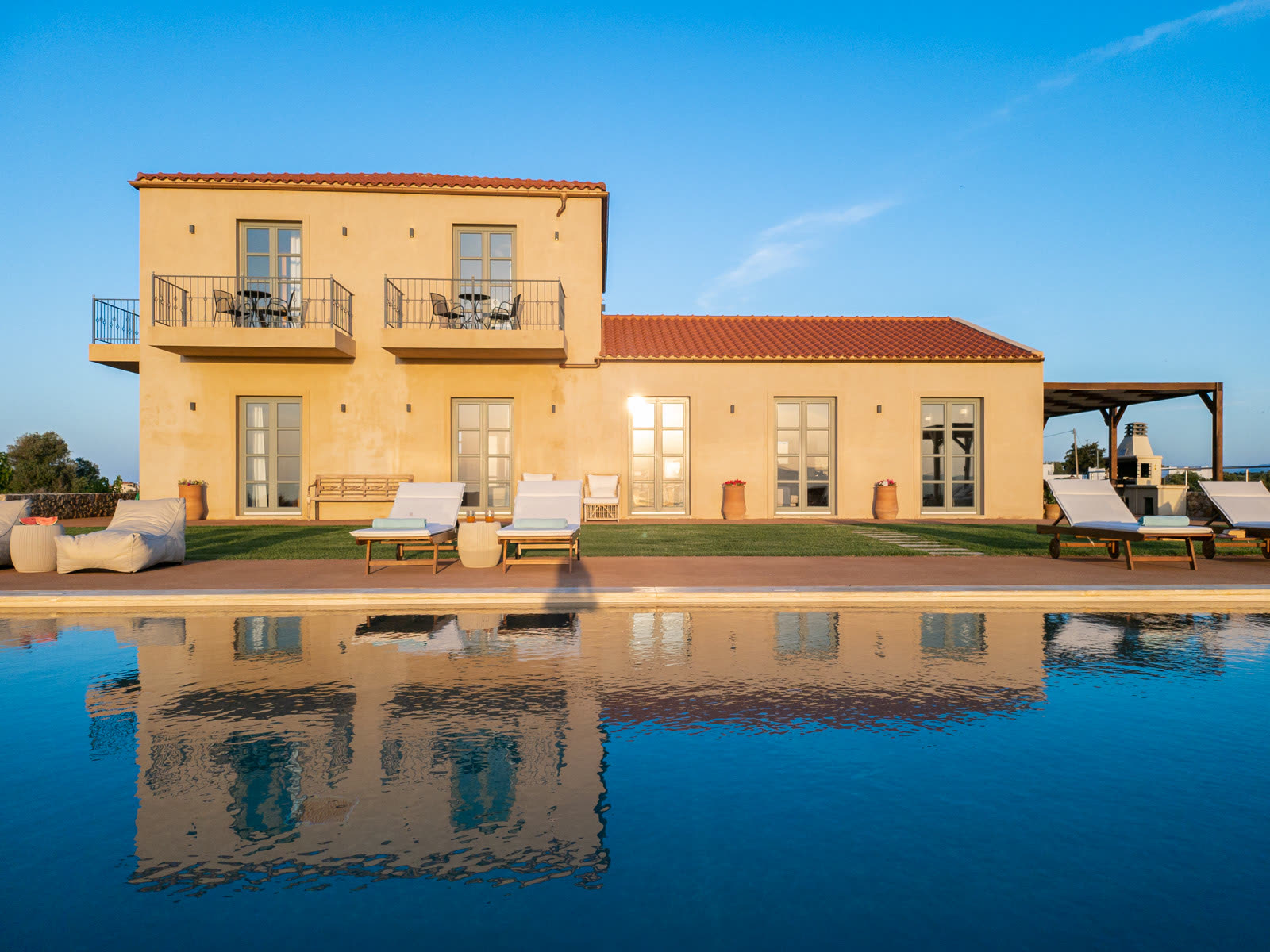 Aquila Villa reflected in the infinity pool at golden hour